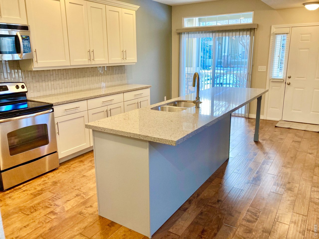 1900 68th Avenue, Unit 5 Greeley, CO 80634 - Photo 4 of 21 a kitchen with stainless steel appliances granite countertop a sink a stove and a wooden floors
