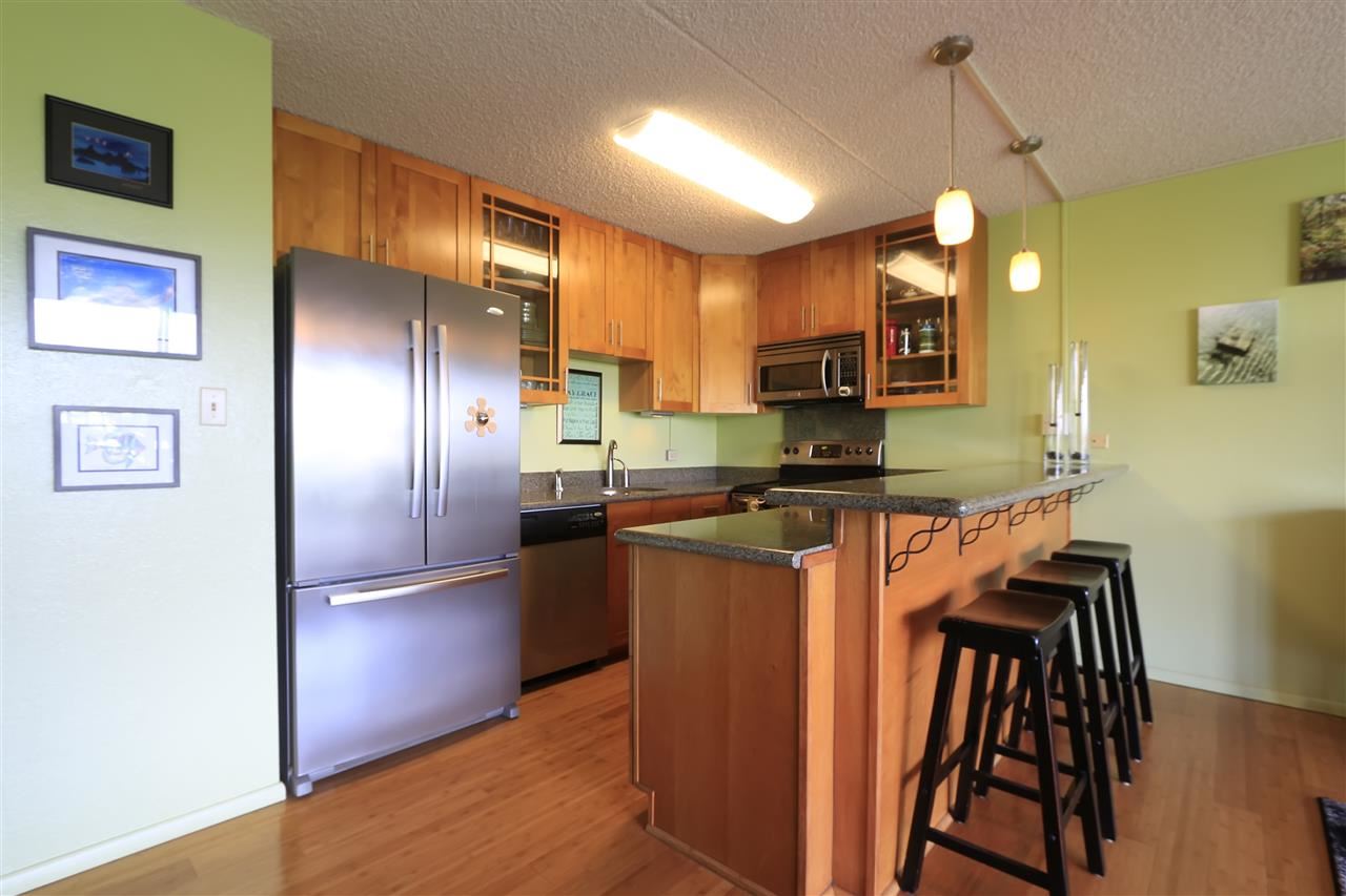 2387 South Kihei Road, Unit C302 Kihei, HI 96753 - Photo 5 of 17 a kitchen with granite countertop stainless steel appliances a refrigerator microwave and stove top oven