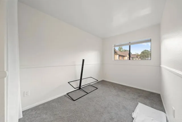 a living room with a window and a ceiling fan