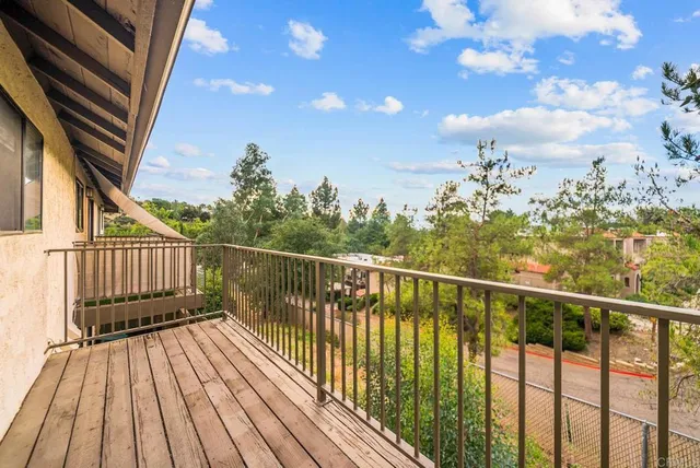 a view of balcony with wooden floor and fence
