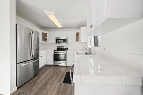 a kitchen with white cabinets and stainless steel appliances