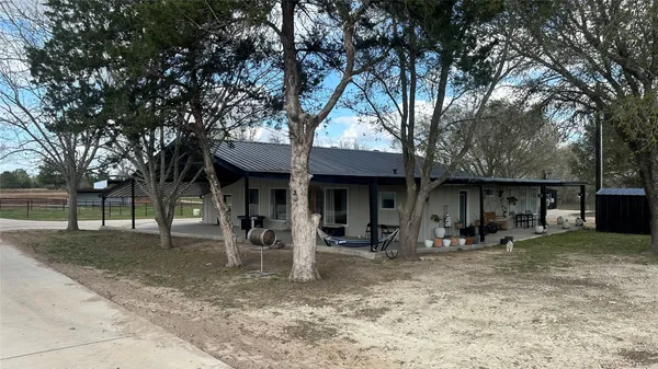 a view of a house with backyard and trees