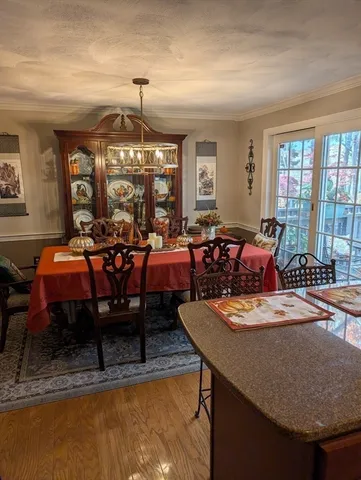 a living room with furniture a chandelier and a dining table