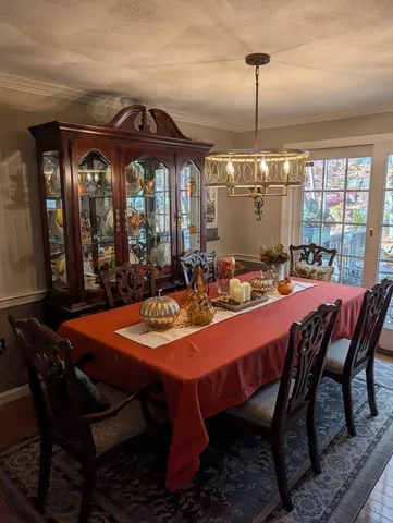 a dining room with furniture a chandelier and window