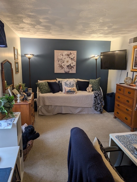 251 Wellman Avenue, Unit 251 Chelmsford, MA 01863 - Photo 24 of 42 a bedroom with furniture and a lamp