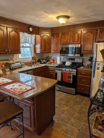 a kitchen with stainless steel appliances granite countertop a sink stove and cabinets