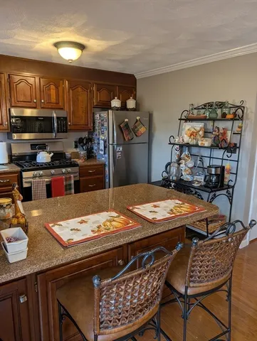 a kitchen with stainless steel appliances granite countertop a stove a refrigerator and a dining table