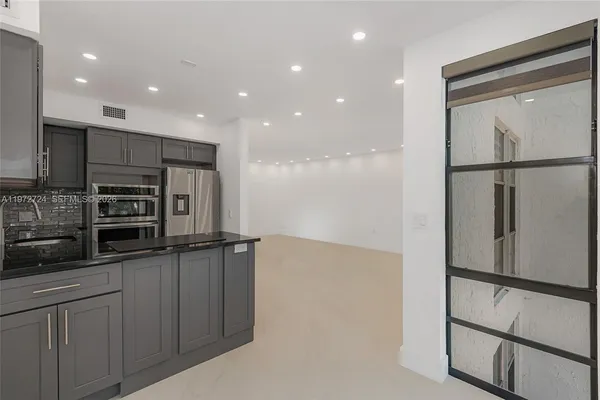 a kitchen with stainless steel appliances a refrigerator and a stove top oven