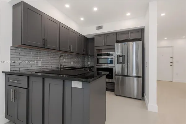 a kitchen with stainless steel appliances granite countertop a refrigerator and a sink