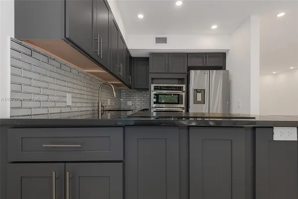 a kitchen with stainless steel appliances granite countertop a sink and cabinets