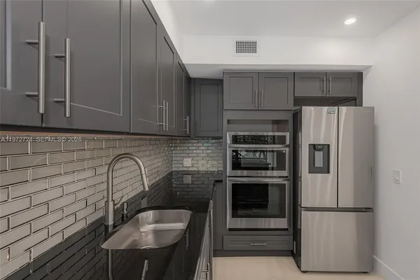 a kitchen with stainless steel appliances a refrigerator and a sink