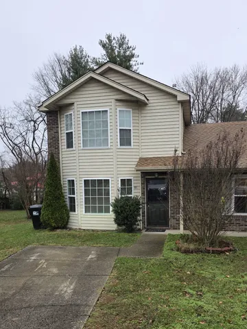 a front view of a house with a garden and yard