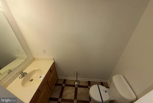 a view of a hallway with wooden floor and a bathroom