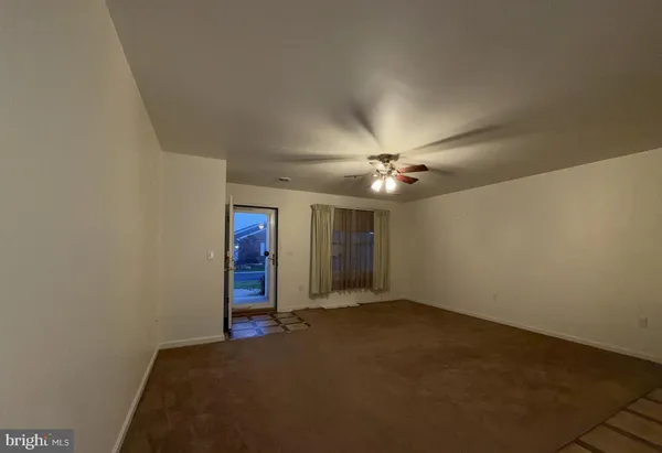 a view of a room with stairs and a ceiling fan
