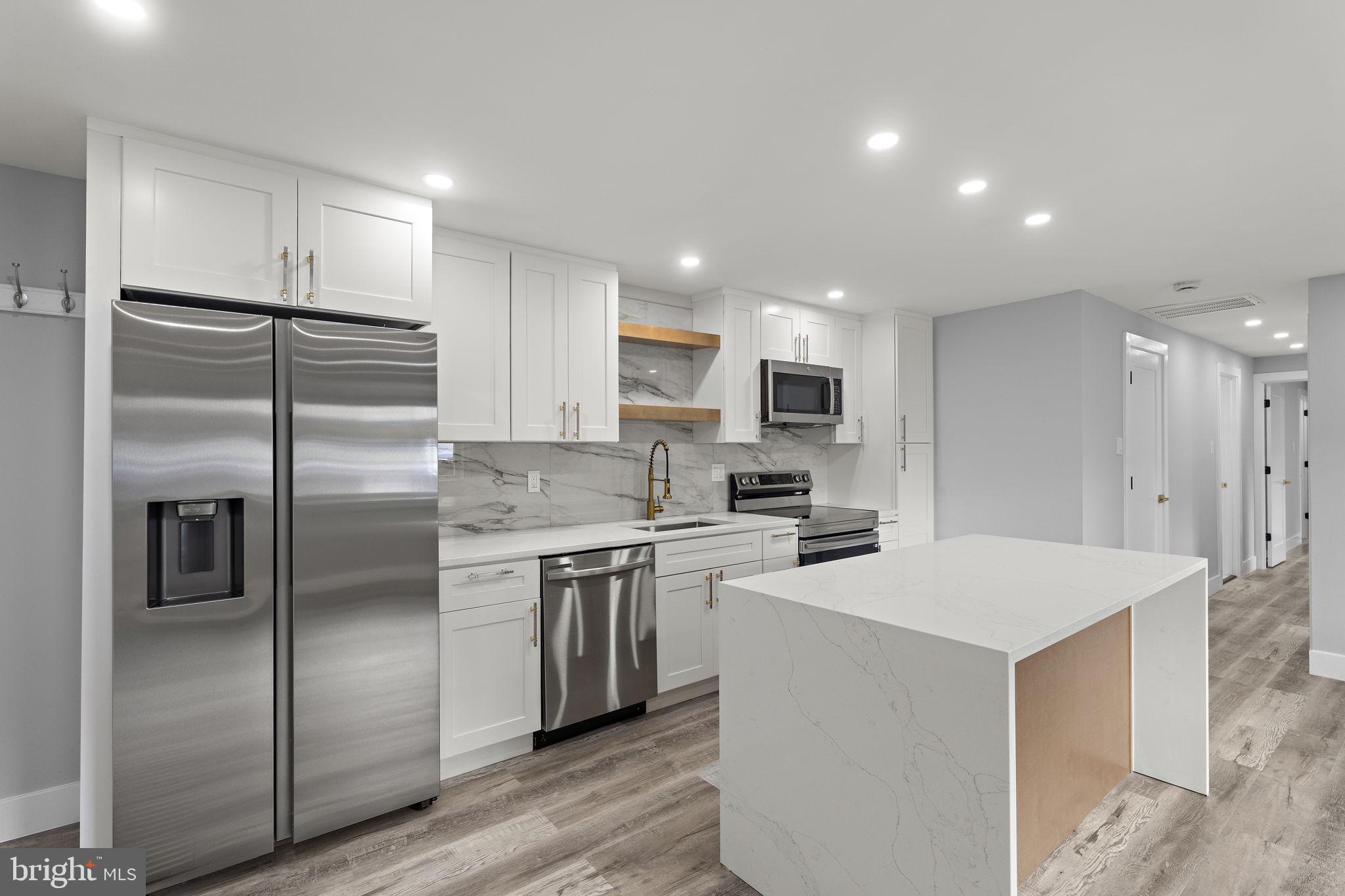 19605 Gunners Branch Road, Unit D Germantown, MD 20876 - Photo 1 of 36 a kitchen with kitchen island a sink stainless steel appliances and refrigerator
