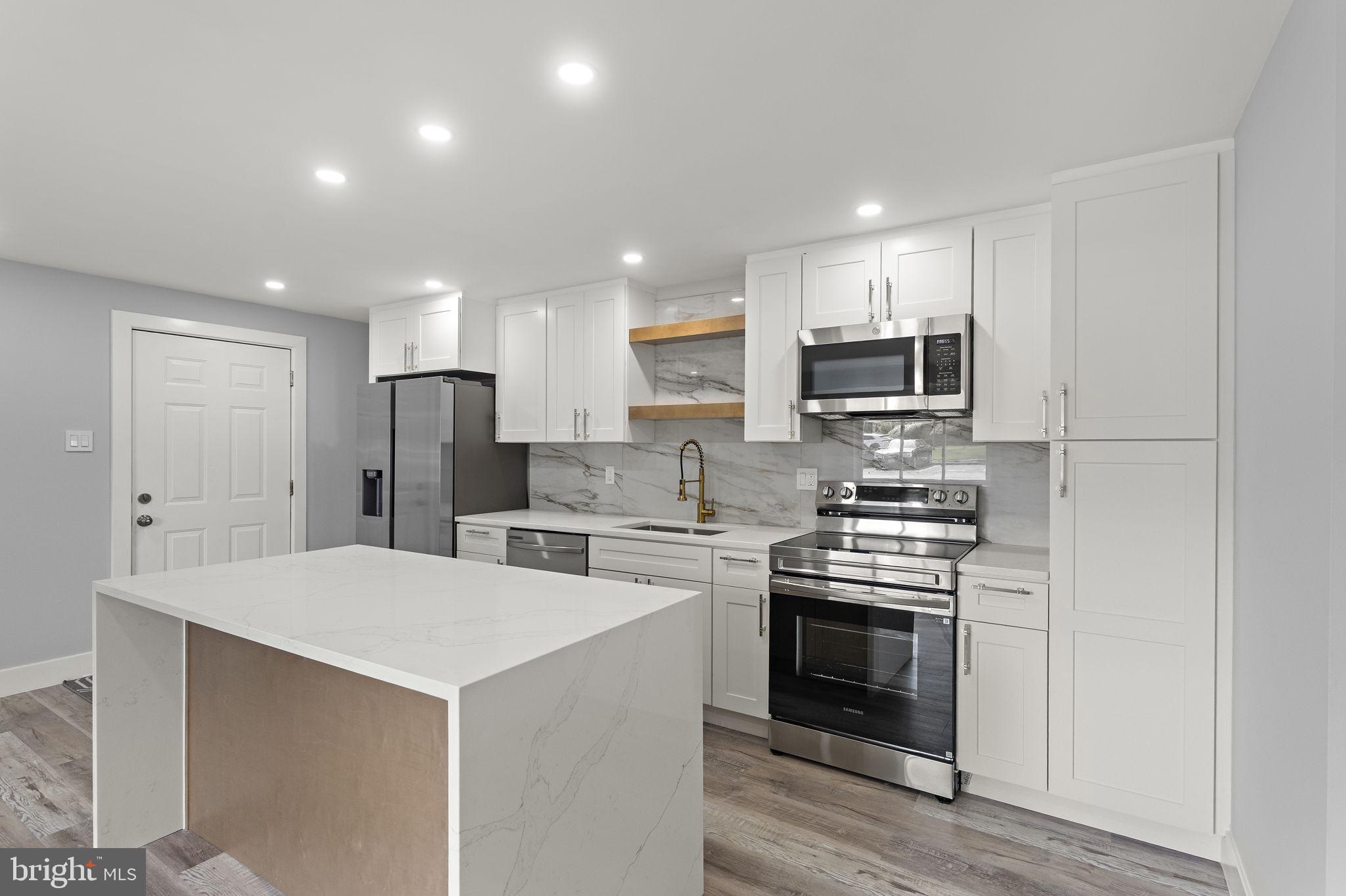 19605 Gunners Branch Road, Unit D Germantown, MD 20876 - Photo 11 of 36 a kitchen with stainless steel appliances a refrigerator sink and stove top oven