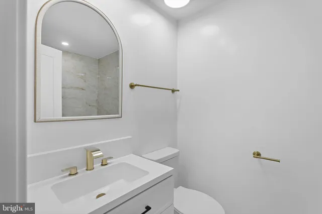 a bathroom with a sink mirror and toilet