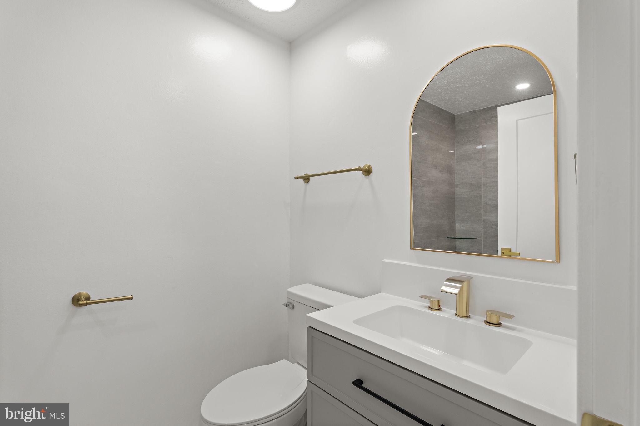 19605 Gunners Branch Road, Unit D Germantown, MD 20876 - Photo 22 of 36 a bathroom with a toilet sink vanity and mirror