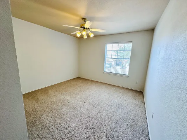 an empty room with closet and a chandelier fan