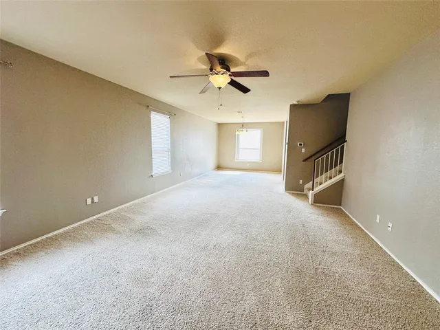 an empty room with windows and ceiling fan view