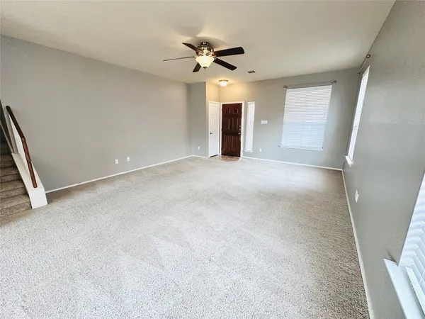a view of an empty room with a ceiling fan