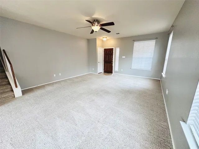 a view of an empty room with a ceiling fan