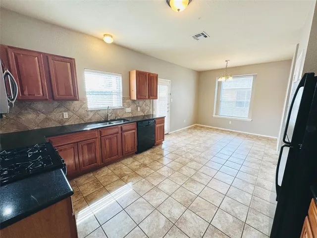 a kitchen with stainless steel appliances a sink stove and cabinets