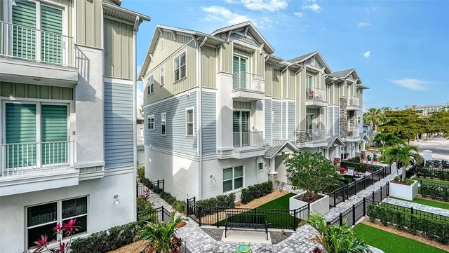 a kitchen with kitchen island a dining table chairs and a refrigerator