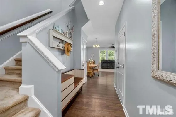a hallway with wooden floor stairs and furniture