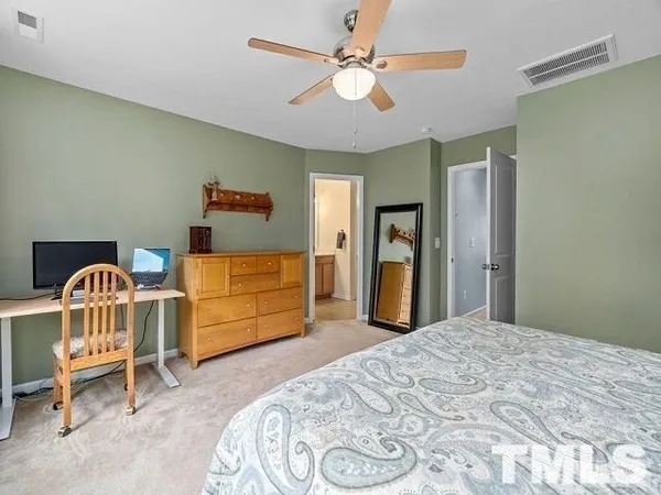 a bedroom with a bed a chandelier and dresser