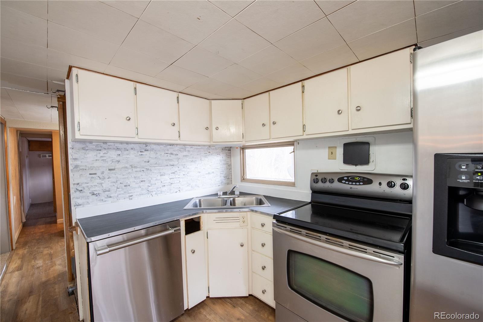 122 Neal Road Bailey, CO 80421 - Photo 10 of 25 a kitchen with granite countertop white cabinets and white appliances