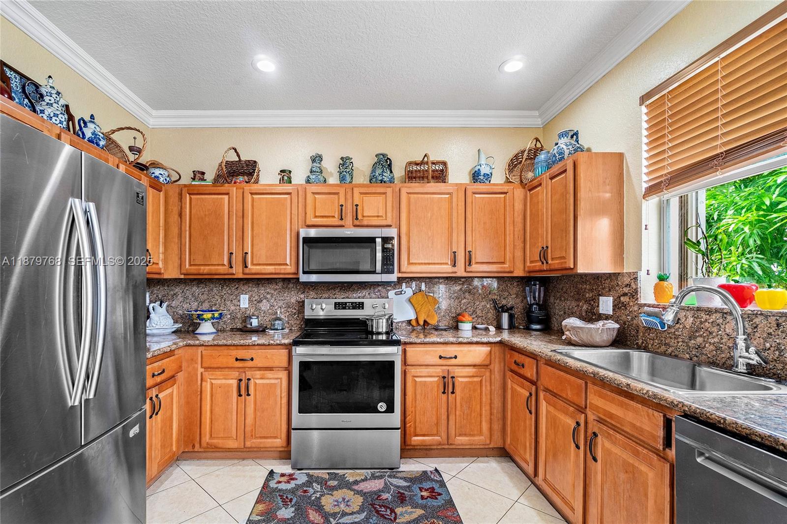 571 Calamint Point Royal Palm Beach, FL 33411 - Photo 14 of 51 a kitchen with stainless steel appliances a stove a sink a refrigerator and a window