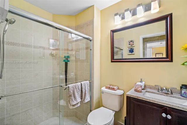 a bathroom with a granite countertop sink mirror and toilet