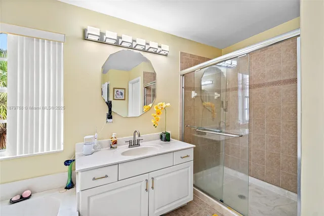 a bathroom with a double vanity sink mirror and shower