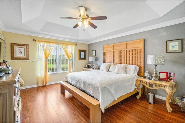 a bedroom with a bed and a large window with wooden floor