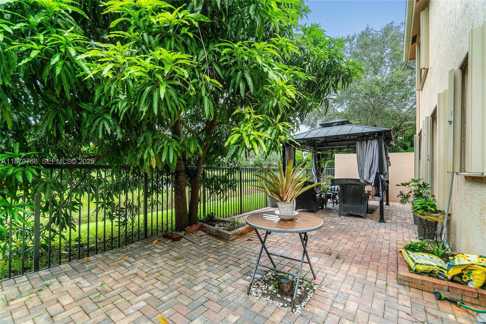 571 Calamint Point Royal Palm Beach, FL 33411 - Photo 31 of 51 a view of a table and chairs in backyard of the house