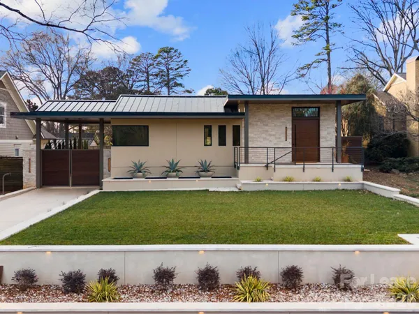 a front view of a house with a garden and patio