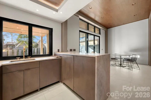 a living room with stainless steel appliances granite countertop a sink and cabinets