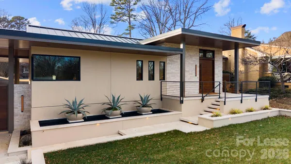 a view of a house with backyard and sitting area