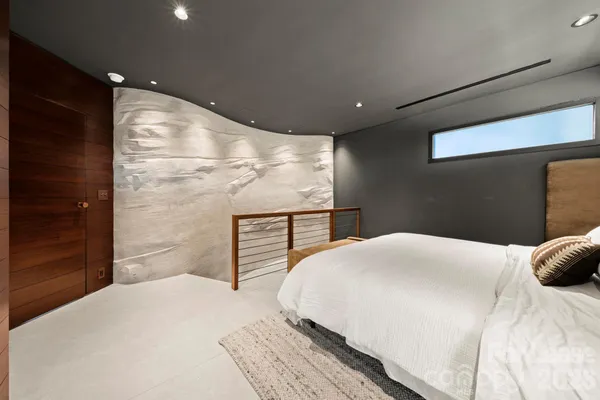 a bedroom with a bed and a large mirror