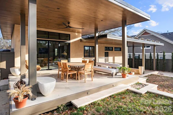 a view of a patio with dining table and chairs under an umbrella