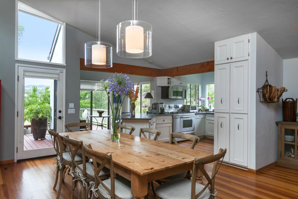 a dining room with wooden floor a chandelier a wooden table and chairs