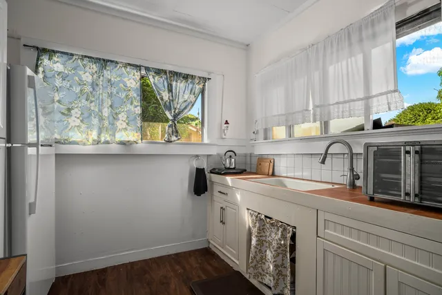 a view of a kitchen sink and wooden floor