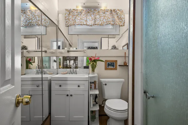 a bathroom with a granite countertop toilet sink and mirror