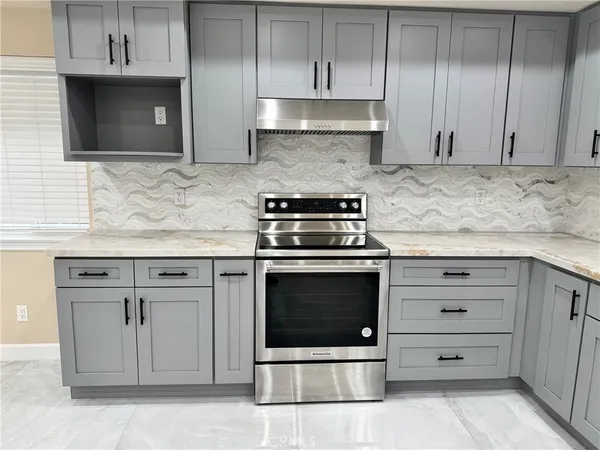 a kitchen with granite countertop white cabinets stainless steel appliances and a sink