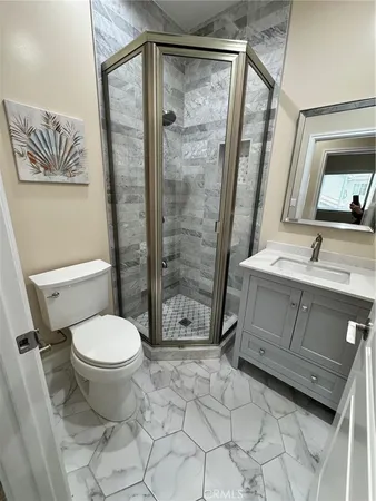 a bathroom with a granite countertop sink toilet and shower