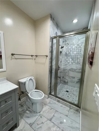 a bathroom with a granite countertop sink toilet and shower