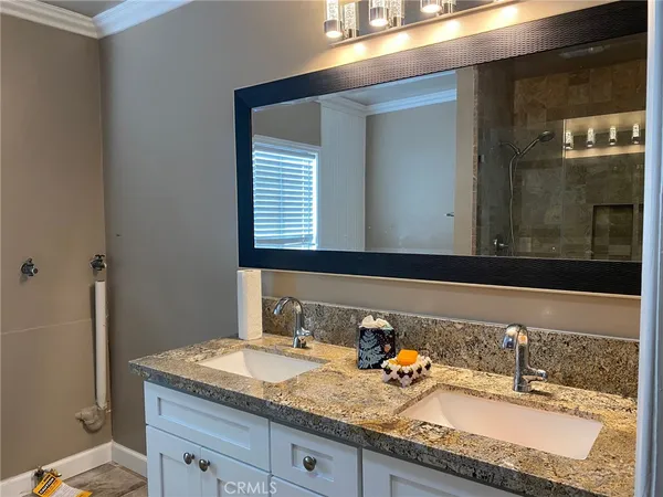 a bathroom with a granite countertop sink and a mirror