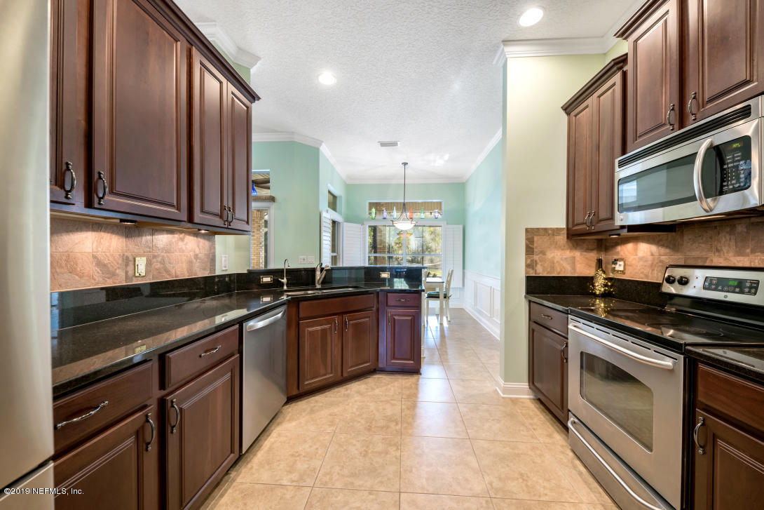 87465 Creekside Drive Yulee, FL 32097 - Photo 16 of 40 a kitchen with stainless steel appliances granite countertop a stove microwave and cabinets