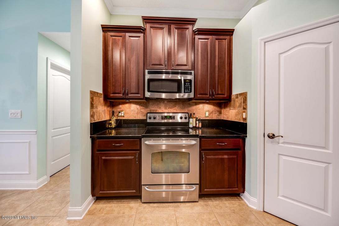 87465 Creekside Drive Yulee, FL 32097 - Photo 18 of 40 a kitchen with granite countertop wooden cabinets and stainless steel appliances